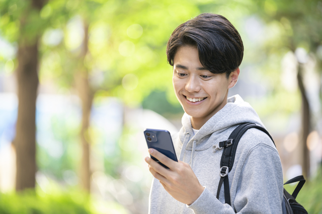 外でスマホを利用する男性